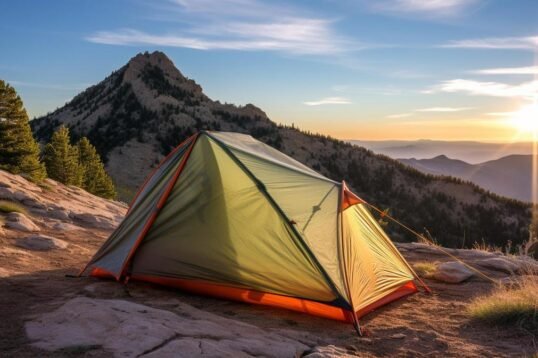 A stunning photo of a lone backpacker's tent in a breathtaking mountain landscape.